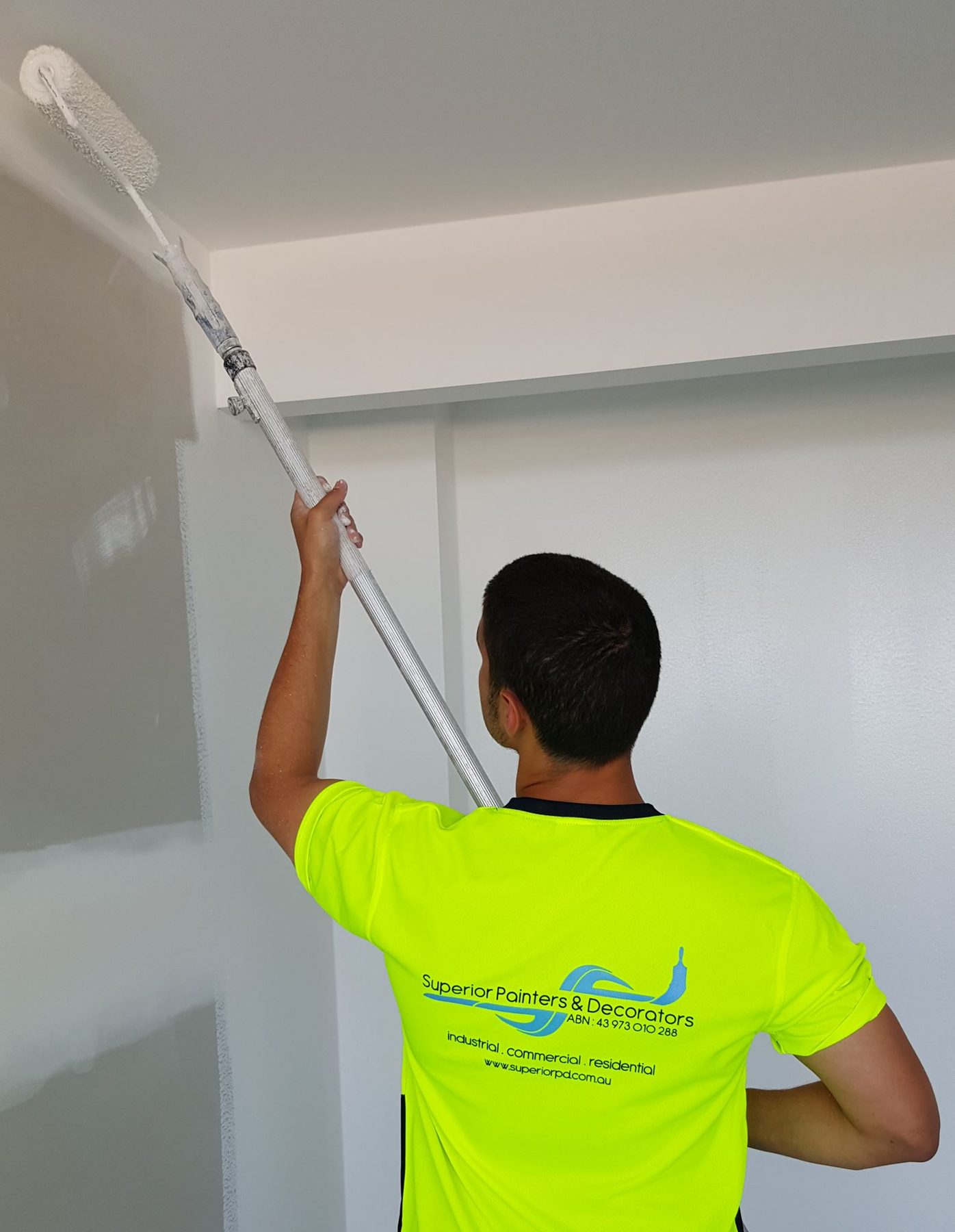 Superior painter rolling a wall in hi-vis